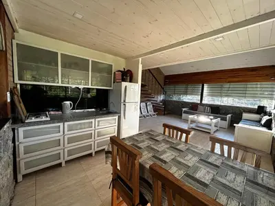 a kitchen and living room with a table and a refrigerator at Terra Nostra in Los Reartes