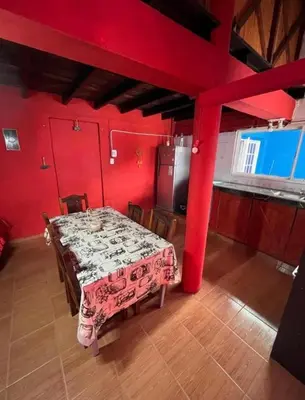 a dining room with a table and red walls at La Morada in Mina Clavero