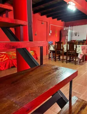 a wooden bench in a room with red walls at La Morada in Mina Clavero