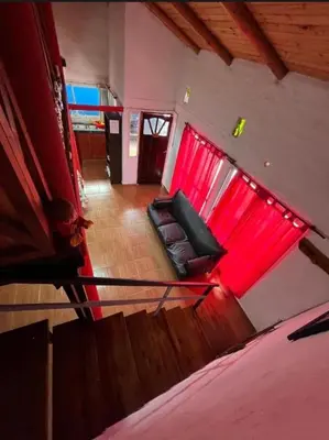 a room with a couch and a red window at La Morada in Mina Clavero