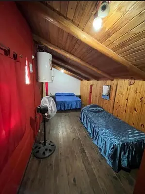 a room with two beds and a fan in it at La Morada in Mina Clavero