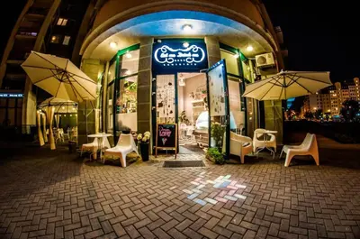 a restaurant with chairs and umbrellas in front of it at Hotel Hawai in Villa Carlos Paz