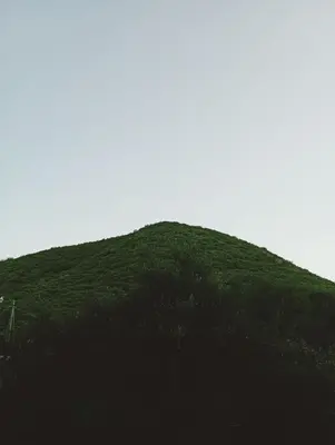 a hill covered in green grass with the sky in the background at Cabañas Mari-Tina in Villa Serranita
