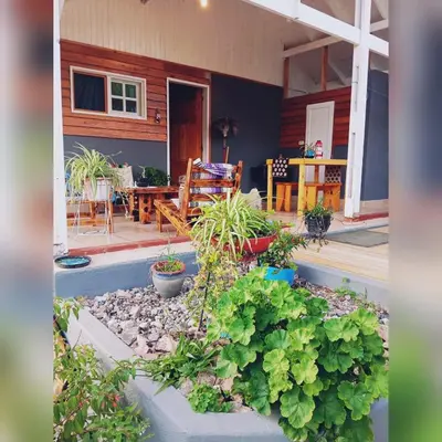 a garden in front of a house with plants at Cabañas Mari-Tina in Villa Serranita