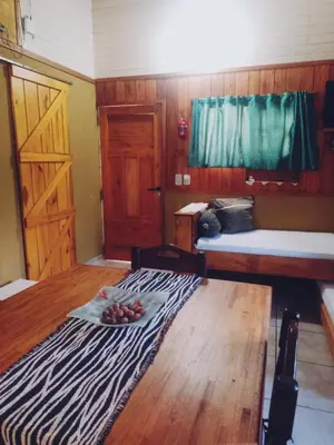 a room with a bed and a plate of fruit on the floor at Cabañas Mari-Tina in Villa Serranita