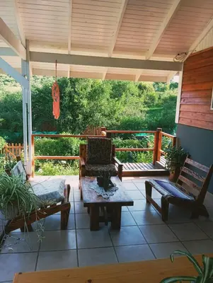 a screened in porch with chairs and a table at Cabañas Mari-Tina in Villa Serranita