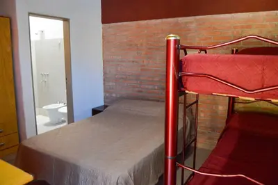 a bunk bed in a room with a brick wall at Complejo Fresia in Mina Clavero