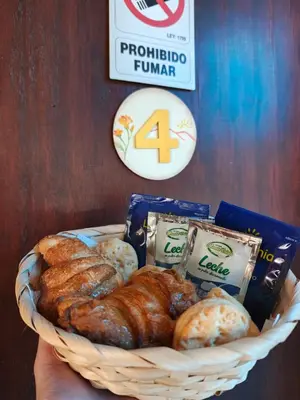 a basket of croissants and other breads in a hand at Complejo Fresia in Mina Clavero