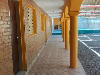 an empty hallway of a building with yellow columns at Complejo Fresia in Mina Clavero