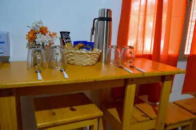 a wooden table with jars and a basket of flowers on it at Complejo Fresia in Mina Clavero