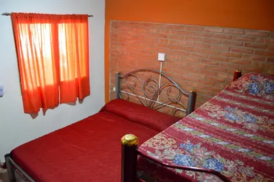 a bedroom with a bed and a brick wall at Complejo Fresia in Mina Clavero