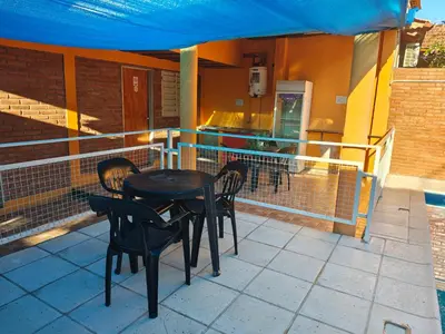 a table and chairs on the balcony of a house at Complejo Fresia in Mina Clavero