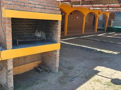 a brick fireplace with a cat sitting on a bench at Complejo Fresia in Mina Clavero