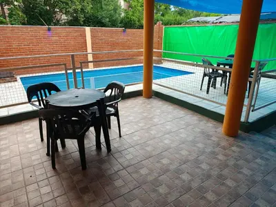 a patio with tables and chairs next to a swimming pool at Complejo Fresia in Mina Clavero