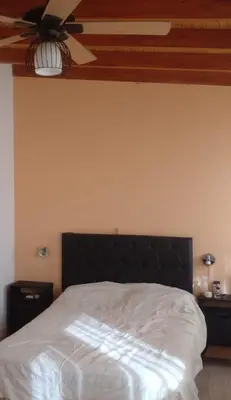 a bedroom with a bed with a ceiling fan at Adorada in Villa Carlos Paz