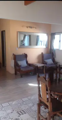 a living room with two chairs and a mirror at Adorada in Villa Carlos Paz