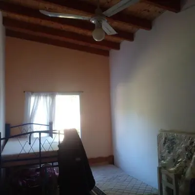 a bedroom with a ceiling fan and a window at Adorada in Villa Carlos Paz