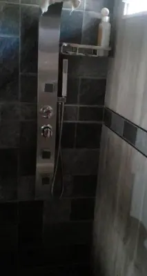 a bathroom with a shower with a hose at Adorada in Villa Carlos Paz