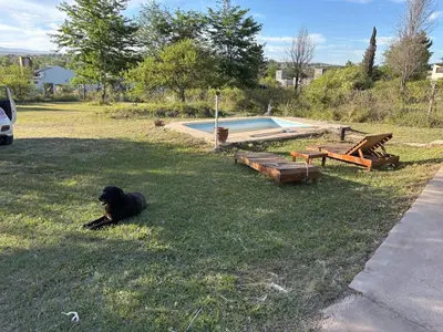 a black dog laying in the grass next to a pool at Casa Mirador Del Lago in Villa Parque Siquiman