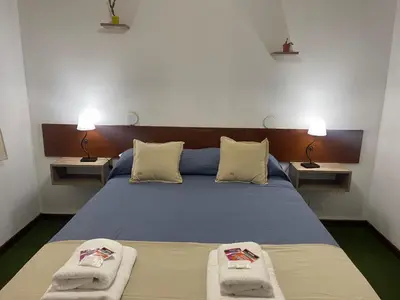 a bedroom with a bed with two towels on it at Hotel Palo Verde in Mina Clavero