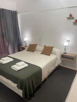 a bedroom with a large bed with two towels on it at Hotel Palo Verde in Mina Clavero