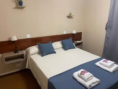 a bedroom with a bed with towels on it at Hotel Palo Verde in Mina Clavero