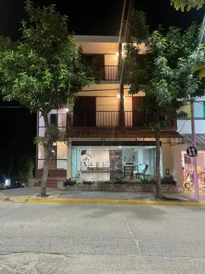 a building with a balcony on the side of a street at Hotel Palo Verde in Mina Clavero
