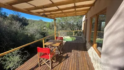 a porch with a table and two chairs on it at Cabaña Peperina in San Javier
