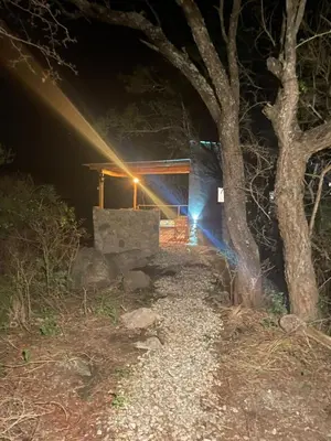 a night view of a building with a tree at Cabaña Peperina in San Javier