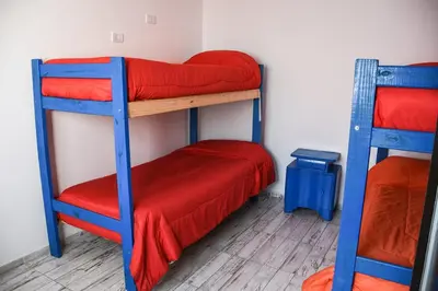 a room with two bunk beds with red sheets at Rio Segundo Colo 2 in Río Segundo