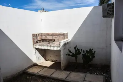a stone bench sitting against a white wall at Rio Segundo Colo 2 in Río Segundo