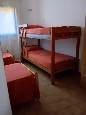 a room with two bunk beds with red sheets at Casa Lago Azul in Villa Santa Cruz del Lago