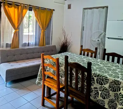 a living room with a table and chairs and a couch at Chalet con puerta al arroyo in Villa General Belgrano