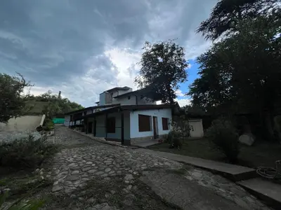 a small house on a gravel road in a yard at Chalet con puerta al arroyo in Villa General Belgrano