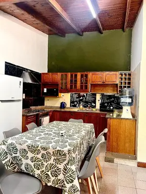 a kitchen with a table and a green wall at Chalet con puerta al arroyo in Villa General Belgrano