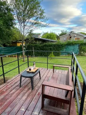 a wooden deck with a table and a bench at Casa del Roble in Alta Gracia
