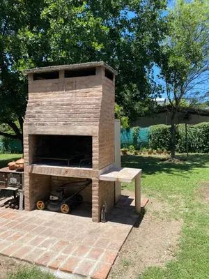a brick oven with a bench in a yard at Casa del Roble in Alta Gracia
