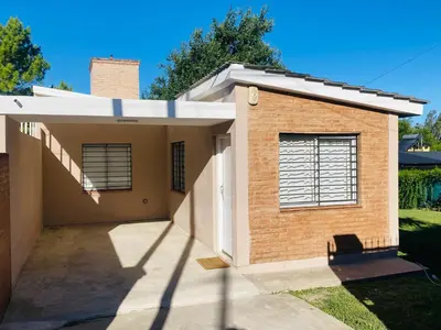 a small brick house with a driveway at Casa del Roble in Alta Gracia