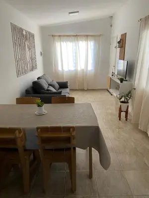 a living room with a table and a couch at Casa del Roble in Alta Gracia
