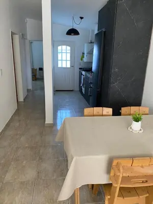 a dining room with a table and chairs and a kitchen at Casa del Roble in Alta Gracia