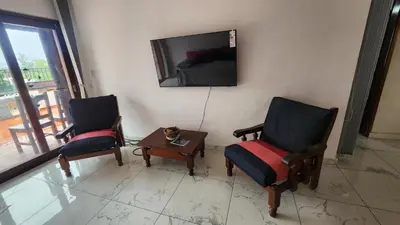a living room with two chairs and a cat sitting on a table at Apartamento con bajada al lago Aldea del Puente in Villa Carlos Paz
