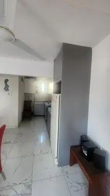 an empty kitchen with a refrigerator in a room at Apartamento con bajada al lago Aldea del Puente in Villa Carlos Paz