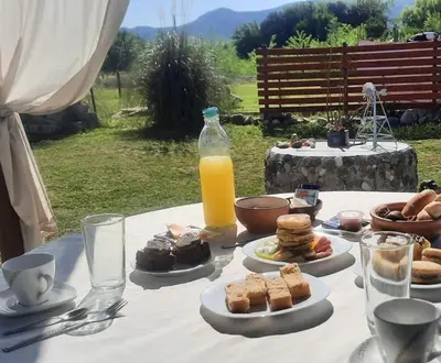 a table with plates of food and a bottle of orange juice at CabañaPaz in Santa Rosa de Calamuchita