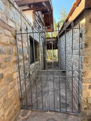 a gate to a stone building with a brick wall at Casa Campo La Carolina in Cordoba
