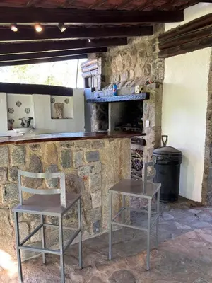 a stone kitchen with two chairs and a counter at Casa Campo La Carolina in Cordoba
