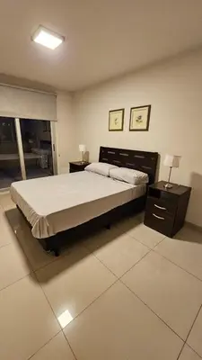 a bedroom with a large bed and two night stands at Departamento en Opera fun 2nd piso in Villa Carlos Paz