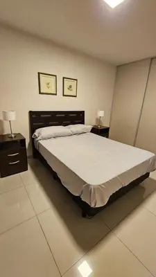 a bedroom with a large bed and two night stands at Departamento en Opera fun 2nd piso in Villa Carlos Paz