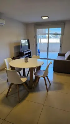 a living room with a table and chairs and a couch at Departamento en Opera fun 2nd piso in Villa Carlos Paz