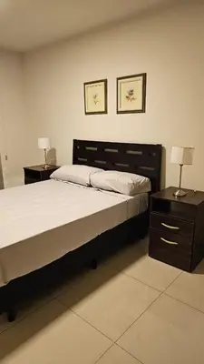 a bedroom with a large bed and two night stands at Departamento en Opera fun 2nd piso in Villa Carlos Paz