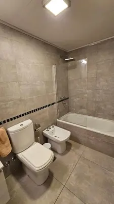 a bathroom with a toilet and a sink and a tub at Departamento en Opera fun 2nd piso in Villa Carlos Paz